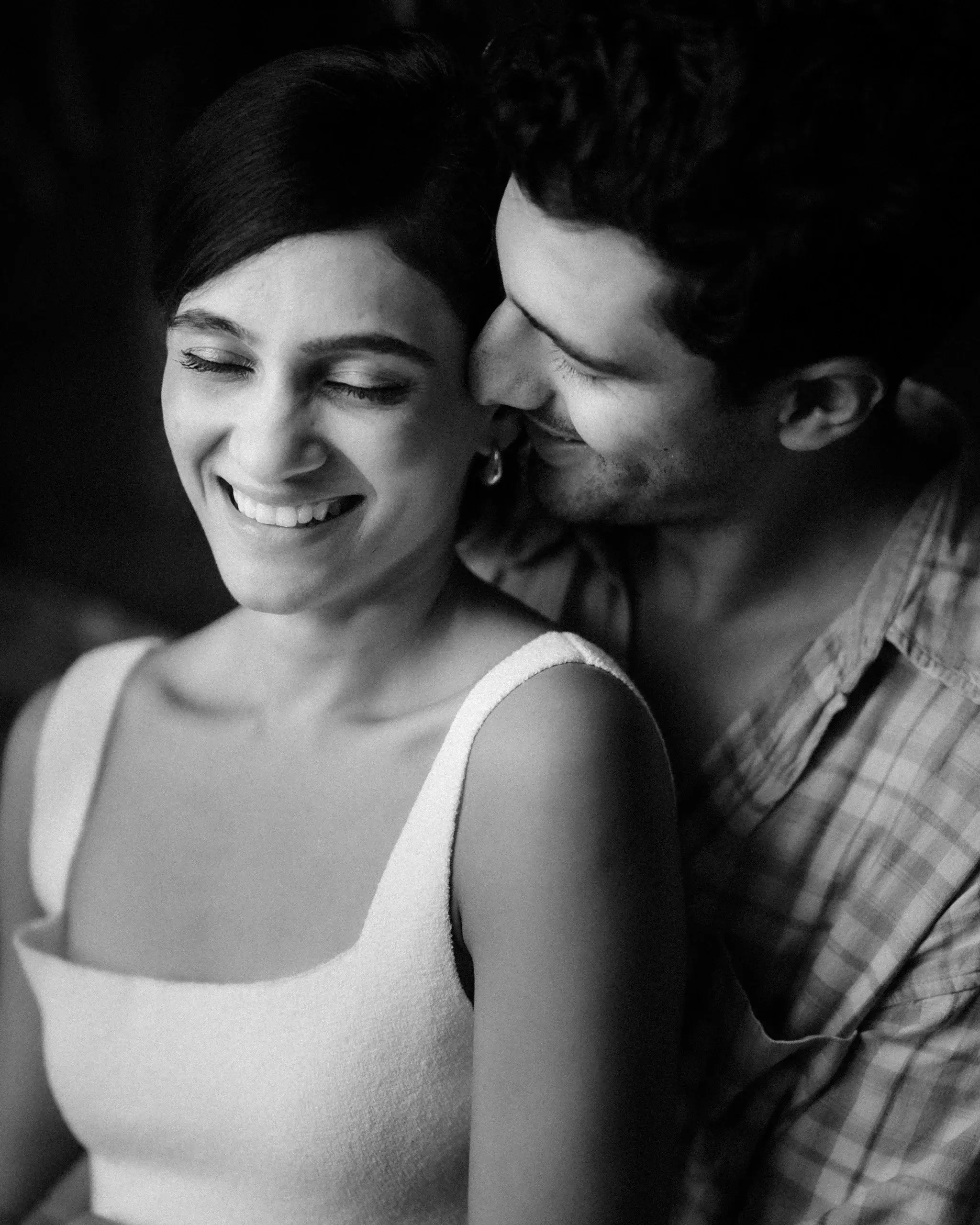 Black and white close-up of a couple, the bride laughing