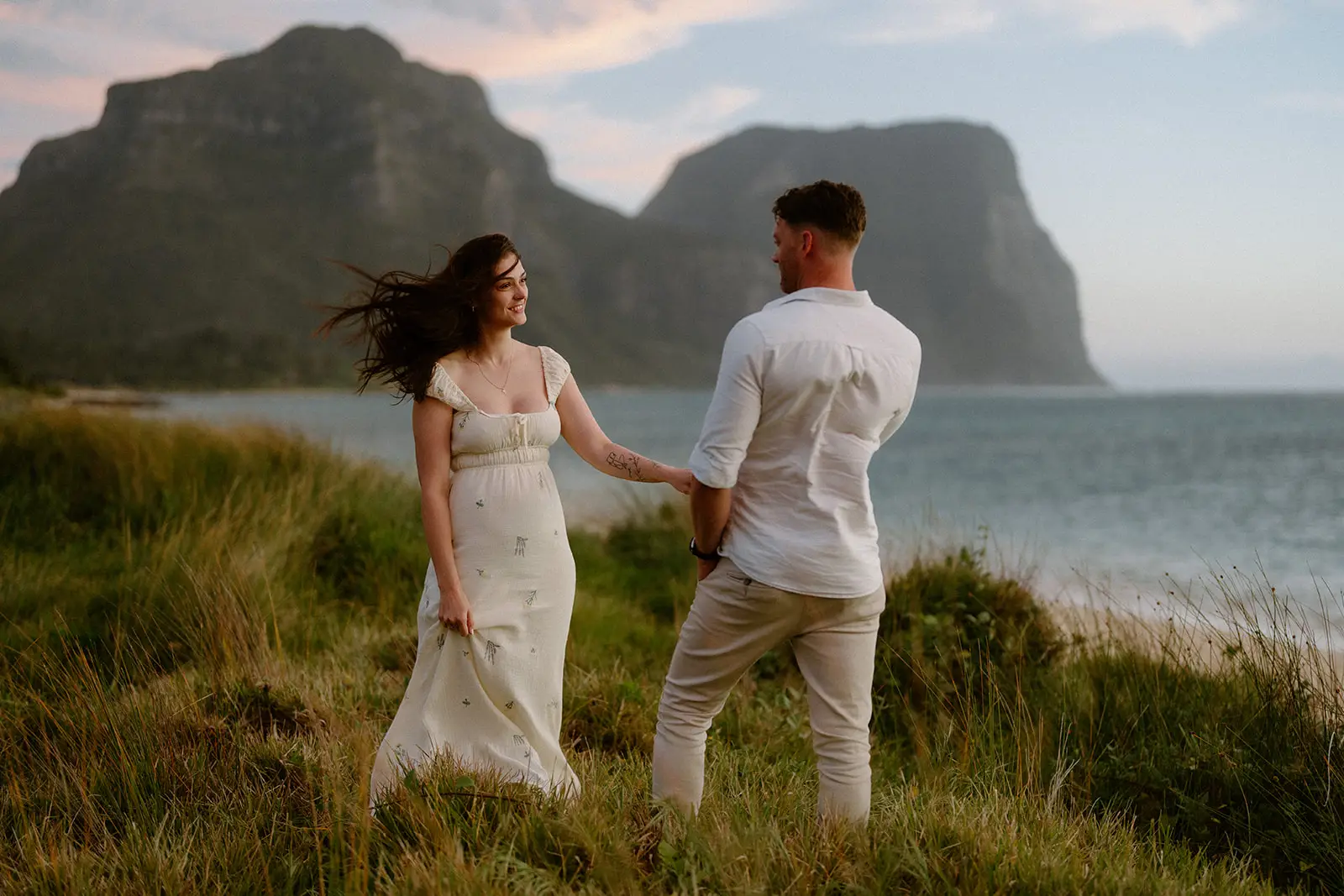 Mel and Brent walking the grass with Mount Gower behind, Lord Howe Island