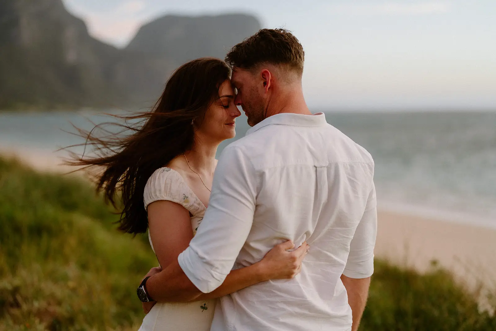 Mel and Brent embracing at golden hour above the beach, Lord Howe Island